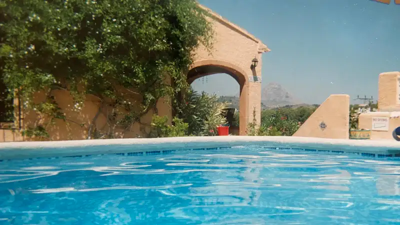 Piscina de una casa con arcos en verano
